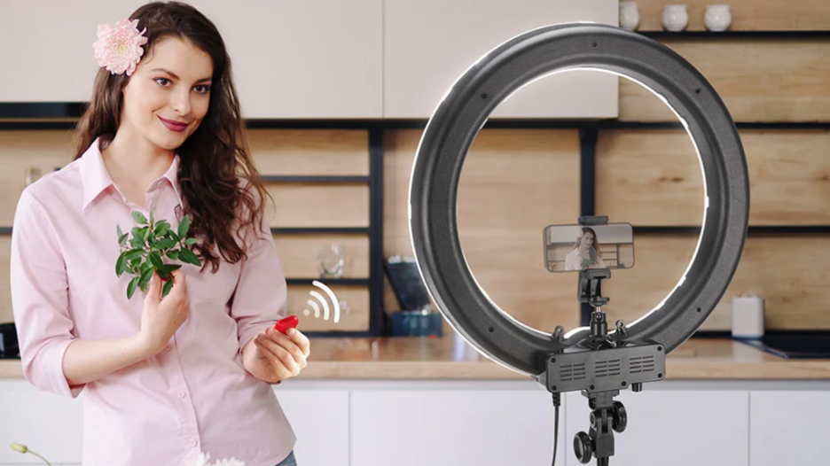 A woman taking a selfie indoors using a ring light.