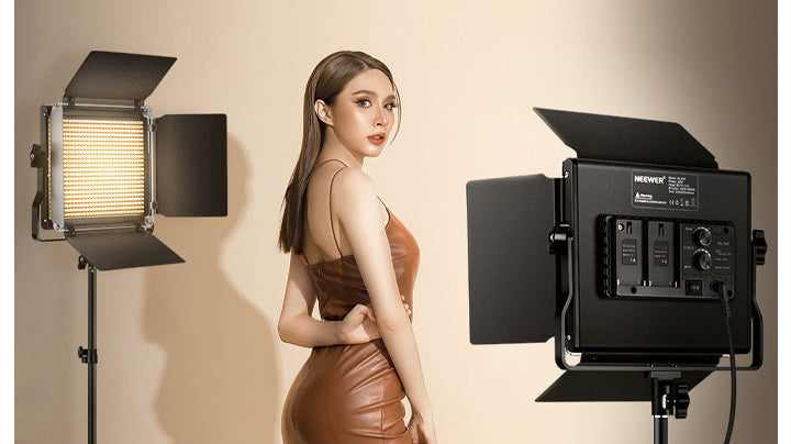 The girl is standing between the two NEEWER NL660.