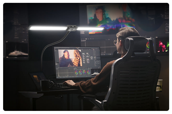 A man is using home office lighting to illuminate his photo editing work.