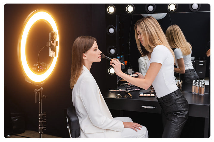 A makeup artist is applying makeup to a girl, using the NEEWER RB18B 18" Cordless Edge-Lit Ring Light