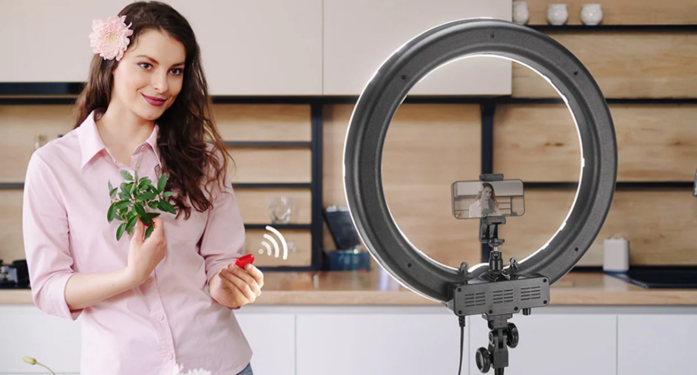 A woman taking a selfie indoors using a ring light.