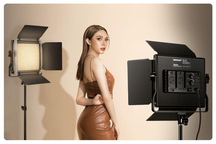 The girl is standing between the two NEEWER NL660.