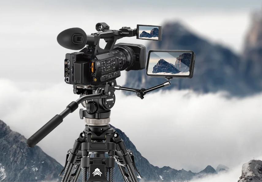 Carbon fiber tripod supports pro video camera in mountains